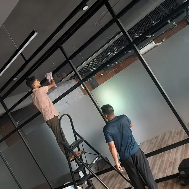 GetPros team cleaning glass partitions on a ladder