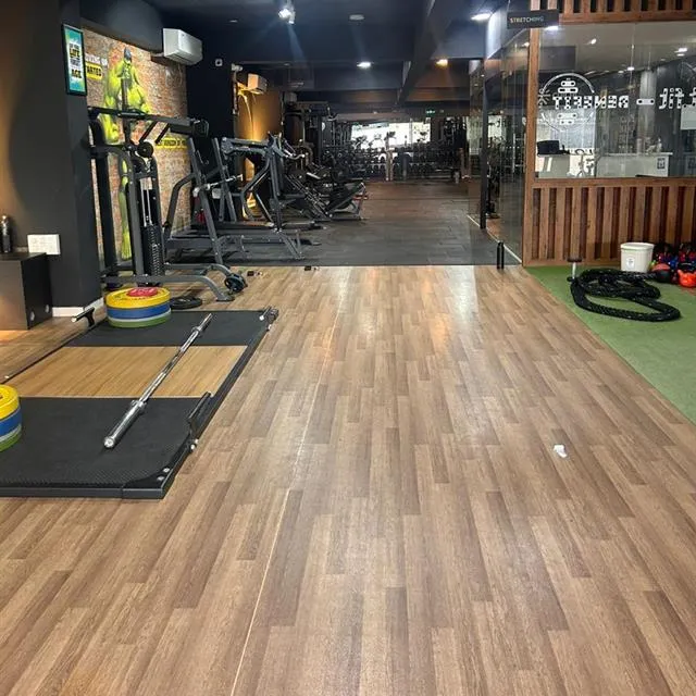 Gym with wooden flooring and weight machines after cleaning