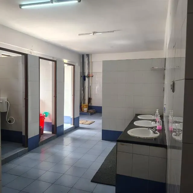 Office washroom with wash basins, tiled walls and floor after cleaning