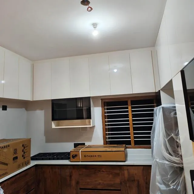 New modular kitchen with white cabinets and wooden base units