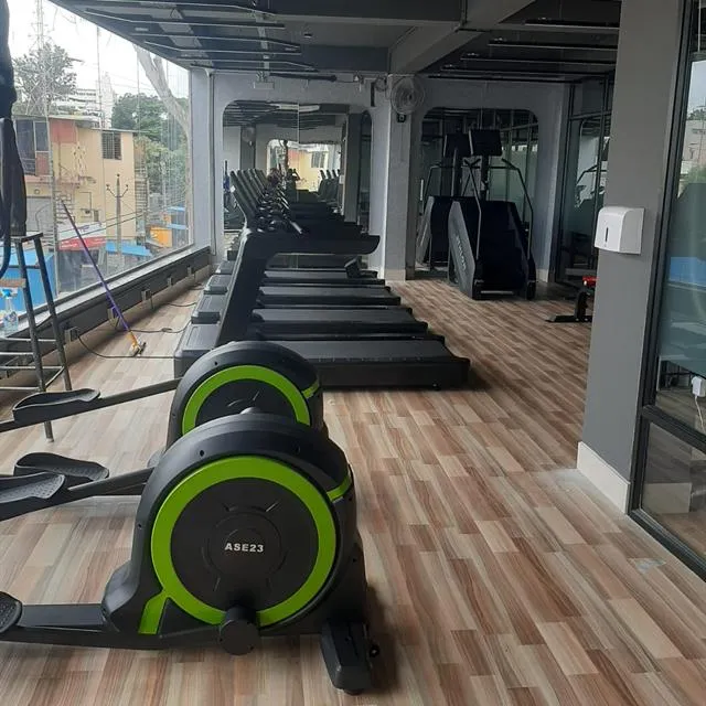 Gym treadmills and cross trainers on a wooden floor