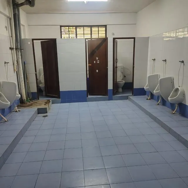 Commercial washroom with urinals, toilet cubicles and tiled floor